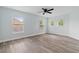 Light-filled bedroom features wood-look floors, ceiling fan, and multiple windows providing ample natural light at 6905 Beargrass Rd, Harmony, FL 34773