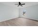 Bright bedroom featuring modern light-colored walls, wood flooring, and a ceiling fan at 6905 Beargrass Rd, Harmony, FL 34773