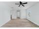 Bright bedroom with wood-look floors, ceiling fan, and multiple doorways creating an open feel at 6905 Beargrass Rd, Harmony, FL 34773