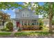 Charming two-story home featuring a welcoming front porch and lush landscaping at 6905 Beargrass Rd, Harmony, FL 34773