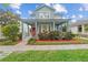 Charming two-story home with a spacious front porch and colorful landscaping at 6905 Beargrass Rd, Harmony, FL 34773