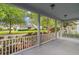 Relaxing covered front porch with white railings and views of the neighborhood at 6905 Beargrass Rd, Harmony, FL 34773