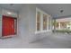 Inviting front porch with a bright red door and elegant exterior details at 6905 Beargrass Rd, Harmony, FL 34773