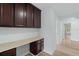 Hallway featuring built-in desk, wood-look floors, and archway leading to an open living space at 6905 Beargrass Rd, Harmony, FL 34773