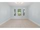 Bright living room featuring large windows and neutral tile flooring at 6905 Beargrass Rd, Harmony, FL 34773