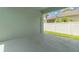 Enclosed back porch featuring concrete flooring and a door leading to the backyard at 6905 Beargrass Rd, Harmony, FL 34773