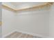 Walk-in closet featuring wood-look flooring, wooden shelves and ample storage space at 6905 Beargrass Rd, Harmony, FL 34773
