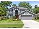 Charming two-story home with a manicured lawn, beautiful landscaping, and an attached two-car garage at 716 Timberwilde Ave, Winter Springs, FL 32708
