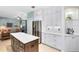 Modern kitchen with stainless steel appliances, white cabinetry, and a center island, open to the living area at 716 Timberwilde Ave, Winter Springs, FL 32708
