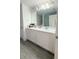 A bright bathroom with dual sinks, white cabinets, and a spacious mirror at 721 Benoi Dr, Davenport, FL 33896