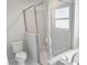 Bathroom featuring a walk-in shower and window, tiled with light gray large format tiles at 841 Fir Ave, Frostproof, FL 33843