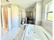 Bathroom with a bathtub, shower, and a marble patterned tile flooring illuminated by natural light at 841 Fir Ave, Frostproof, FL 33843