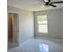 Bedroom with gray walls, light floors, and a window overlooking the yard at 841 Fir Ave, Frostproof, FL 33843