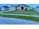 Inviting single-Gathering home boasts a well-manicured lawn, two car garage, and neatly landscaped garden beds at 841 Fir Ave, Frostproof, FL 33843