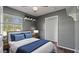 Cozy bedroom with a large window, walk-in closet, and stylish gray walls at 8733 Catbriar Ln, Orlando, FL 32829