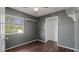 Bedroom features closet, window, a shelf and dark-toned walls and hardwood floors at 8733 Catbriar Ln, Orlando, FL 32829