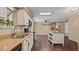 An open kitchen features white cabinets, stainless appliances, skylight, a kitchen island, and wood floors at 8733 Catbriar Ln, Orlando, FL 32829