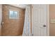 Shower stall with tile, window and shower curtain with bathroom door at 8733 Catbriar Ln, Orlando, FL 32829