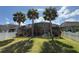 Backyard with lush green lawn, palm trees, and a screened-in patio, providing privacy at 8986 Fullerwood Ave, Orlando, FL 32832