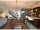 Bright dining room boasts hardwood floors, a stylish chandelier, and a view of the staircase and kitchen at 8986 Fullerwood Ave, Orlando, FL 32832
