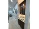 Hallway featuring a granite countertop, dark cabinets, and a decorative mirror at 8986 Fullerwood Ave, Orlando, FL 32832