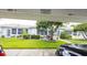 Home's exterior features a shaded parking area and charming patio with outdoor seating amid manicured landscaping at 904 Michigan Ave, St Cloud, FL 34769
