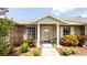 Inviting front entrance with brick facade, covered porch, manicured shrubs, and decorative potted plants at 904 Michigan Ave, St Cloud, FL 34769
