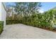 Large brick paver patio and lush backyard with verdant greenery and privacy hedge at 933 Jasmine St, Celebration, FL 34747