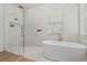 Modern bathroom with a glass-enclosed shower, soaking tub, and light-colored finishes at 933 Jasmine St, Celebration, FL 34747