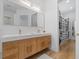 Bright bathroom with a double sink vanity, wood cabinets, and an adjacent walk-in closet at 933 Jasmine St, Celebration, FL 34747
