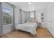 Well-lit bedroom with hardwood floors, a comfortable bed, and large windows offering natural light at 933 Jasmine St, Celebration, FL 34747