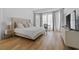 Bright bedroom with a large bed, floor-to-ceiling windows, and light wood flooring at 933 Jasmine St, Celebration, FL 34747
