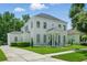 Elegant white home featuring a beautifully landscaped yard and classic architectural details at 933 Jasmine St, Celebration, FL 34747