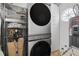 Laundry room with stacked washer and dryer, plus storage cabinets and shelving at 933 Jasmine St, Celebration, FL 34747