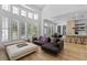 Open-concept living room featuring large windows, modern decor, and an adjacent kitchen with bar seating at 933 Jasmine St, Celebration, FL 34747