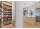 A walk-in pantry with custom shelving, organized containers, and stainless steel appliances in the background at 933 Jasmine St, Celebration, FL 34747