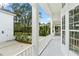 An inviting covered porch with white railings and views of a manicured side yard at 933 Jasmine St, Celebration, FL 34747