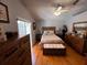 This main bedroom features hardwood floors, a ceiling fan, and a large window at 10207 Cody Ln, Orlando, FL 32825