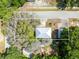 Aerial view of the property showcasing the house, garage, and tree-covered lot at 1101 Oregon Ave, St Cloud, FL 34769