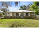 Cozy single story home featuring a metal roof, manicured lawn, and a serene outdoor setting at 1101 Oregon Ave, St Cloud, FL 34769