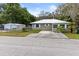 Quaint home featuring a metal roof and a detached garage on a neatly kept lawn with mature trees at 1101 Oregon Ave, St Cloud, FL 34769