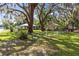 Spacious front yard with mature trees and lush landscaping, showcasing the homes and neighborhood at 1101 Oregon Ave, St Cloud, FL 34769