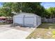 View of the detached two-door garage with a concrete driveway surrounded by a grassy yard at 1101 Oregon Ave, St Cloud, FL 34769