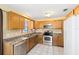 Bright kitchen with oak cabinets, stainless steel appliances, and a clean design with tiled flooring at 1101 Oregon Ave, St Cloud, FL 34769