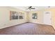 Inviting living room with natural light, featuring a ceiling fan, plush carpeting, and an open doorway at 1101 Oregon Ave, St Cloud, FL 34769