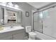 Bright bathroom with a neutral color scheme, modern vanity, and glass-enclosed shower-tub combo at 1129 Park Ridge Cir, Kissimmee, FL 34746