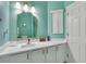 Stylish bathroom with a gold-framed mirror, white vanity, and mint-colored walls at 1129 Park Ridge Cir, Kissimmee, FL 34746