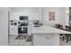 Modern kitchen features white cabinets, stainless steel appliances, quartz countertops, and tile floors at 1129 Park Ridge Cir, Kissimmee, FL 34746