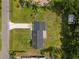 Aerial view of a well maintained property with a dark roof, green lawn, and mature trees at 1158 Stroupe Rd, Kissimmee, FL 34744