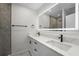 Modern bathroom featuring a double vanity with black fixtures and an illuminated mirror at 1158 Stroupe Rd, Kissimmee, FL 34744